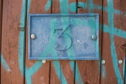 Graffitti on door of house number 3