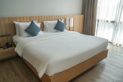 minimal double bed with white mattress in luxury hotel bedroom
