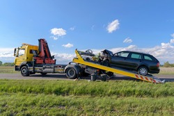 After an accident the crashed car is pulled onto a tow truck