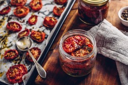 Preserving in Olive Oil of Sun Dried Tomatoes with Herbs in a Glass Jar
