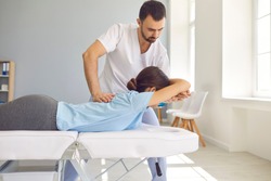Woman having chiropractic back adjustment. Osteopath, physiotherapist or alternative medicine specialist curing patient's spine problems. Pain relief. Sport injury rehabilitation. Medical massage