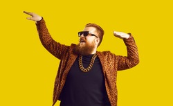 Rich bearded man in leopard print outfit and cool glasses vibing to music. Happy redhead showman, funny party guy, showbiz entertainer, glamour show presenter, night club goer dancing and having fun