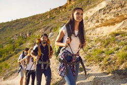 Group of friends tourists with backpacks traveler in the mountains on a hike hiking along the route in nature in summer. Outdoor activities adventure for people.