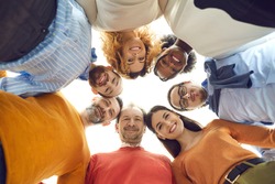 Diverse dream team united like one family. Group portrait of happy positive mixed race people, male and female business partners or colleagues, huddling touching heads in work meeting, bottom view