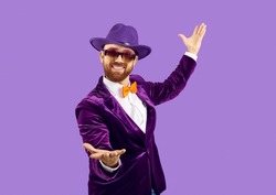 Portrait of smiling man performer in disco jacket isolated on purple studio background make tricks. Happy male entertainer or party man in suit and hat communicate with audience. Party concept.