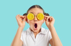 Amazed teen girl child isolated on blue studio background in funny glasses with oranges feel shocked by summer deal or offer. Stunned small kid wear cool eyewear. Seasonal sale concept.