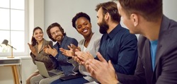 Multiracial team of happy business people applauding colleague for good presentation at work meeting. Group of cheerful employees smile and clap hands showing their recognition to teammate. Banner