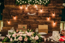 brown wooden wall at the table in the banquet hall for a wedding celebration with a monogram for the names on it