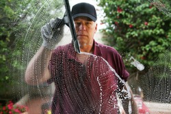 A friendly and professional a window washer soaps and cleans a window with a squeegee, leaving them Squeaky Clean. Everyone Loves Clean Windows especially in the Spring and Summer Season. 