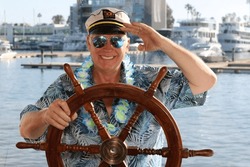 Photo Booth. Yacht. A man poses for pictures while in a Photo Booth on a Yacht at a Party. Everyone loves a Photo Booth even on Yachts and Pleasure Boats. Captain Spike on his Pleasure Boat. Smile. 