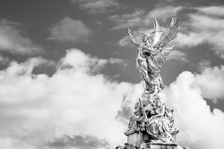 London, UK: Victory Goddess golden statue on top of the Victoria Memorial located in front of the Buckingham Palace; outdoor goddess statue in black and white