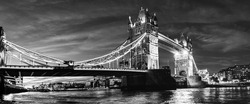 London, England, UK: Night view of the Tower Bridge over river Thames in black and white
