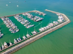 Aerial top view of a lot of white yachts and sailboats moored in marina on a turquoise water, hundreds of boats in port, Pattaya, Chonburi