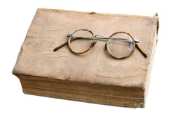 Old book with antique glasses isolated on a white background