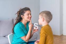 Speech therapist and little patient training articulation. Speech therapist teaches the boys to say the letter S. Shot of a speech therapist during a session with a little boy 