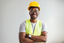 Happy African Builder Workman Standing Pleased Crossing Hands Posing On Gray Studio Background. Copy Space.  Industrial engineer 