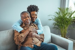 Afro hispanic-latino father and daughter together at home. Family is everything - Family Tie. Adult Daughter Hugging Senior Man. Senior black man and his middle aged daughter embracing, close up