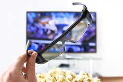 3d-glasses in the hand against TV-set 
