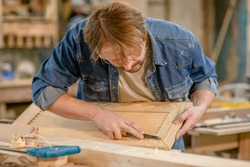 Carpenter uses chisel in carpentry in a carpentry workshop