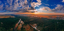 Panoramic air view of colorful hot air ballons flying over park and river in small european city at summer sunset, Kiev region, Ukraine