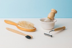 Stylish wooden shaving and washing accessories on a white table. Men's accessories for appearance care.