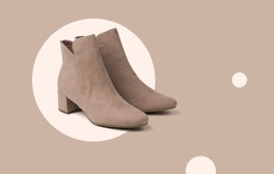 Stylish beige women's suede boots on an abstract beige background. Minimal concept of women's shoes.