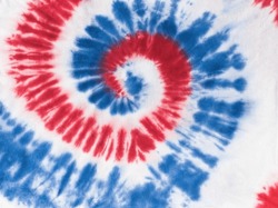 Red and blue tie dye pattern on white fabric. Manual dyeing of fabric.
