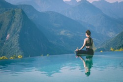 Beautiful Asian woman practice yoga Lotus pose on the pool above the Mountain peak in the morning in front of beautiful nature views in SAPA vietnam,Feel so comfortable and relax with yoga in holiday