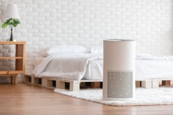 Air purifier in cozy white bedroom for filter and cleaning removing dust PM2.5 HEPA and virus in home,for fresh air and healthy Wellness life,Air Pollution Concept