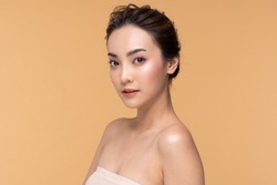 Wellness Asian young woman looking at camera clean fresh and nutural pure skin,Pretty girl smile with be moist skin on her face shining like a model,Facial treatment of beauty woman,isolated on Beige