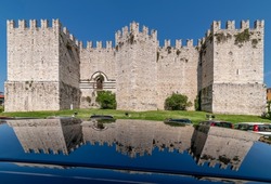 The ancient castle of the emperor of Prato, Italy, is reflected on the shiny surface of a car