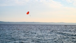 Parasailing on the sea. towed parachute against blue sky. Parachute and boat on the sea at summer. Tourist having fun with parachute on the sky. Extreme sport and adventure. 