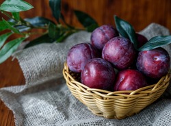 Plum. Fresh plum. Harvest. Autumn harvest. Autumn. Blue plums. Yellow plum. Fresh plums on a wooden surface. Fresh plums on wooden table background.