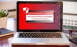 Ransomware text on computer screen, Cyber attack concept. Office business wood desk background.