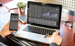 Stock exchange market analysis, Man working with a laptop, monitoring app on screen, office desk background. Trade platform, forex trading. Binary option, candlestick chart.