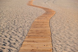 Beach boardwalk. Wooden planks winding empty walkway on sandy beach, Elafonissos Greek island, summer vacations in Greece