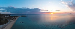Sithonia Chalkidiki, Greece. Sunrise over calm ocean aerial panoramic view. Dramatic sunset seascape at Ormos Panagias, Orange and blue color shades sky.