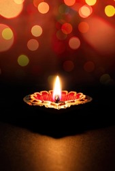 Happy Diwali. Diya lamp lit, colorful rangoli, dark bokeh light background. Deepavali Hindu Festival of lights celebration.