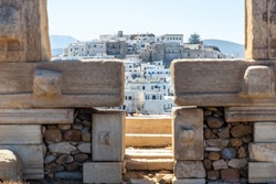 Naxos island, Greece. Chora traditional buildings, view through Portara, the marble pillars gate of Apollo Temple