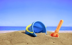 Summer vacations - Bucket and spade on a sandy beach