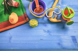 Summer beach toys on blue wooden background with copy space - top view