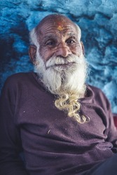 Portrait of an old indian man, old aged man with wrinkles on his face smiling into the camera.