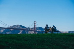 friends having a picnic in front of the golden gate in a park