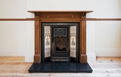 antique fireplace with carved wooden frame and hand painted ceramic tiles