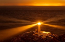 Lighthouse on coastal island with horizon at South Stack in Holyhead, North Wales.sunset on the Isle of Anglesey
