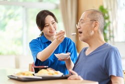 A caregiver who assists the elderly with meals