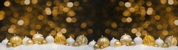 Festive christmas ornaments advent celebration holiday holidays banner greeting card panorama long - golden and white baubles, balls on snow, with black concrete wall and bokeh lights in background