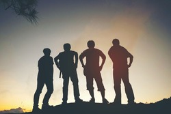 silhouette of friends standing in sunset
