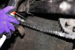 motorcycle chain cleaning, maintenance and repair of chain seals with a spray.