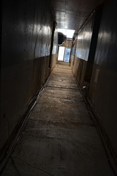 gloomy dormitories old corridor, a window full of light at the end of the corridor, the idea of a poor life, the path to change, concept, dark gloomy corridor, old mold walls